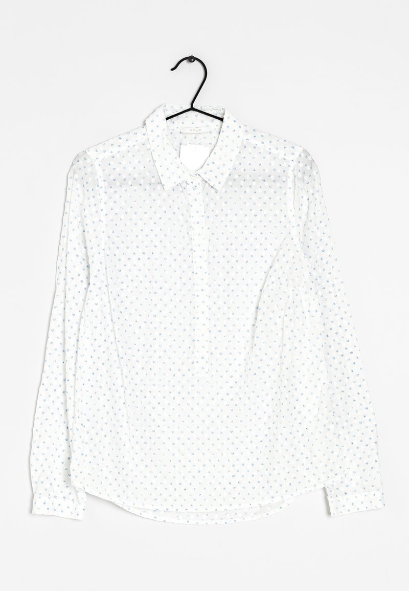 Bílá dlouhá blůza s dlouhými rukávy, s límečkem na knoflíky a malými modrými květinovými vzory. Vyrobena z lehkého, průsvitného materiálu. Zaoblený lem.