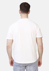 Maglietta bianca a maniche corte con scollo rotondo, realizzata in cotone. Tessuto liscio, orlo dritto e senza motivi o marchi visibili.