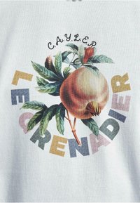 T-Shirt mit einem cremfarbenen Hintergrund, der eine große Illustration eines Pfirsichs mit Blättern zeigt, umgeben von buntem Text, der "LE GRENADE" schreibt.