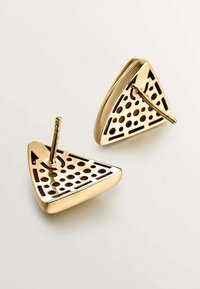 Pendientes triangulares de oro con patrones recortados y un cierre trasero seguro. Textura suave con acabado pulido, creando una superficie reflectante.