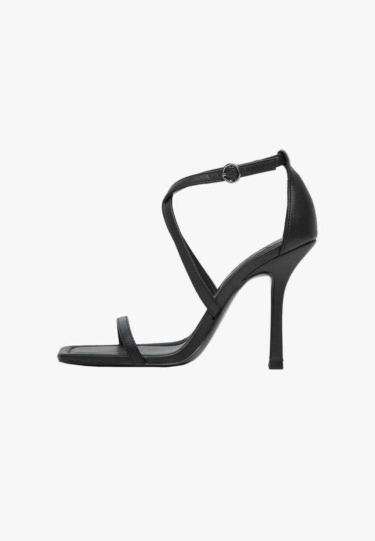 Sandale noire à talon haut avec un design à brides, un bout carré et une bride de cheville réglable. Confectionnée en cuir lisse avec une finition élégante.
