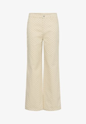 Pantalon large beige à petits pois noirs, avec bouton sur le devant, fermeture éclair, passants pour ceinture et poches.