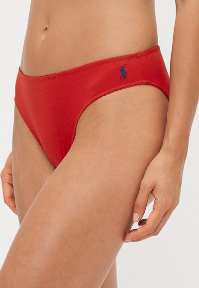 Red cotton bikini brief with a smooth texture, featuring a scalloped waistband and a small blue logo on the side.