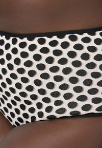 Czarno-białe bikini w groszki o gładkiej fakturze, z czarnym paskiem w talii i elastycznym dopasowaniem.