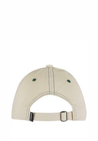 Baseball cap, lys beige stof, buet skygge, grønne syninger, justerbar rem bagpå, cirkulære ventilationshuller på toppen.