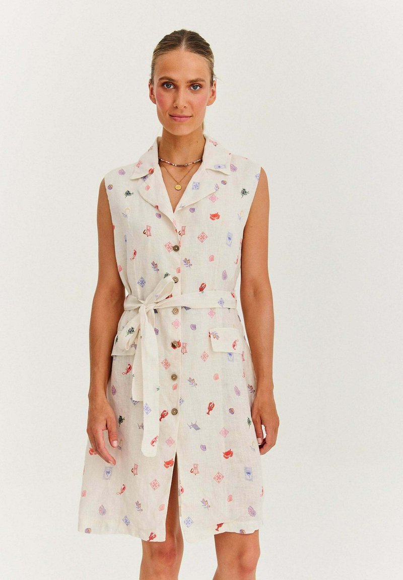 Sukienka lniana bez rękawów w kolorze ecru z kwiatowym wzorem, z kołnierzykiem, zapięciem na guziki, paskiem w talii i dwiema kieszeniami.