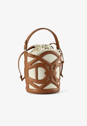 Sac seau en cuir marron avec un intérieur en tissu beige, présentant des motifs géométriques découpés et une fermeture à cordon réglable.