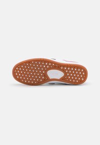 Hvit sneakersåle med gummifarget gummiyttersåle, med et vaffelmønster og et sentralt logoområde som viser "VANS."