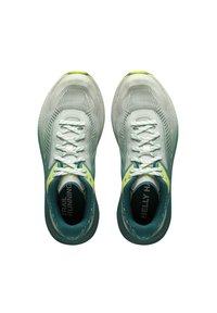 Zapatillas de trail running en verde claro y azul verdoso con parte superior de malla texturizada, cordones blancos y acentos amarillos en contraste.