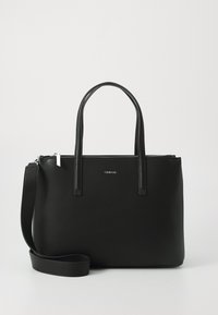 Borsa a tracolla nera realizzata in materiale liscio con due manici corti e una tracolla rimovibile. Presenta una chiusura superiore con zip e un dettaglio del logo frontale.