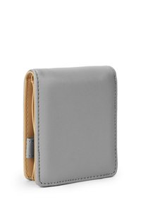 Compact wallet in smooth gray leather, featuring a contrasting beige interior. Rounded corners and stitching detail enhance its design.
