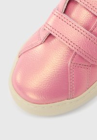 Ροζ δερμάτινο παπούτσι με γυαλιστερό φινίρισμα, διαθέτει δύο λουράκια με βέλκρο, στρογγυλεμένη μύτη και υφασμένη ελαστική σόλα.