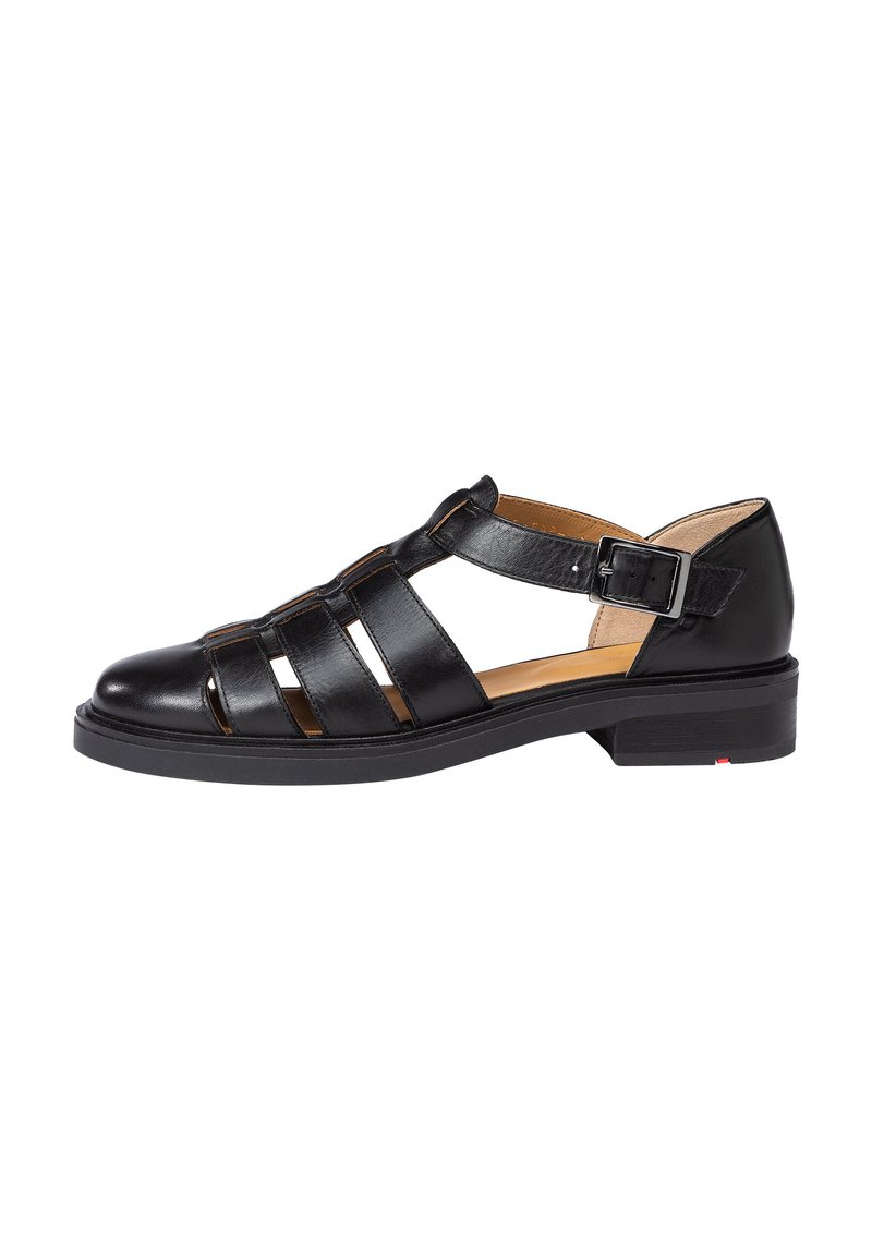 Black leather sandal featuring multiple cut-out straps, an adjustable ankle buckle, and a low stacked heel. Smooth texture with minimal accents.