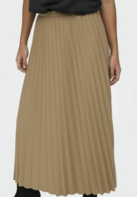 Falda maxi plisada en un color marrón claro, con una textura suave y una cinturilla ancha. El diseño incluye plisadosverticales para mayor movimiento.