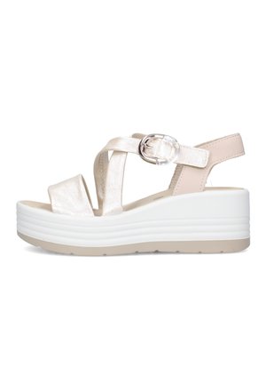 Sandalo con zeppa beige con suola piattaforma spessa bianca, cinturini incrociati e fibbia argentata sulla caviglia.