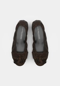 Ballerines en suede marron avec un bout arrondi et un nœud décoratif agrémenté de franges. Doublure intérieure lisse avec logo imprimé sur la semelle intérieure.