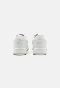 Sneaker bianche con tomaia in pelle liscia, collarino imbottito e logo in rilievo sul tallone. Suola in gomma spessa con grip testurizzato.