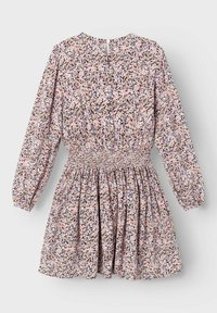 Blumenmusterkleid mit langen Ärmeln, elastischem Bund und gerafftem Rock. Der Stoff hat einen pastellpinken Hintergrund mit schwarzen und lila Blumenmustern.