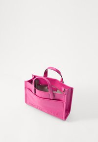 Borsa a mano in pelle rosa con doppio manico corto, chiusura a zip e logo "MICHAEL KORS" in rilievo sul davanti. Texture liscia e lucida.