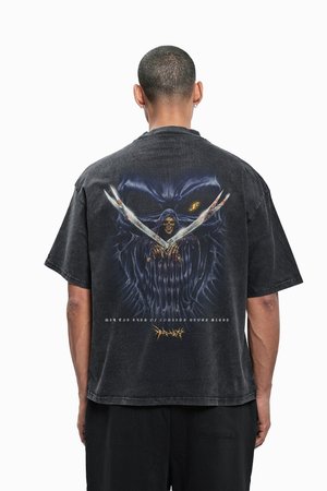 Melna oversized T-krekls ar grafikas druku uz muguras, attēlojot skeletu ar šķērēm, papildināts ar tumšiem toņiem un tekstūrām.