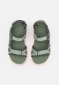 Grønne justerbare sandaler med mesh- og stofremme, gummisåler med en lille lyserød accent og sikre spænder. 