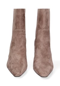 Een paar bruine suède enkelboots met puntige neuzen, zichtbare stiksels en blokhak, getoond van voren op een witte achtergrond.