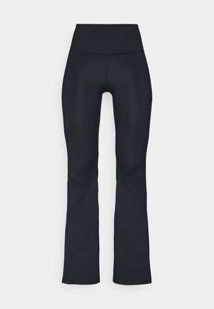 Zwarte uitlopende legging gemaakt van een rekbare stof met een hoge tailleband. Heeft een gladde textuur en minimale stikseldetails.
