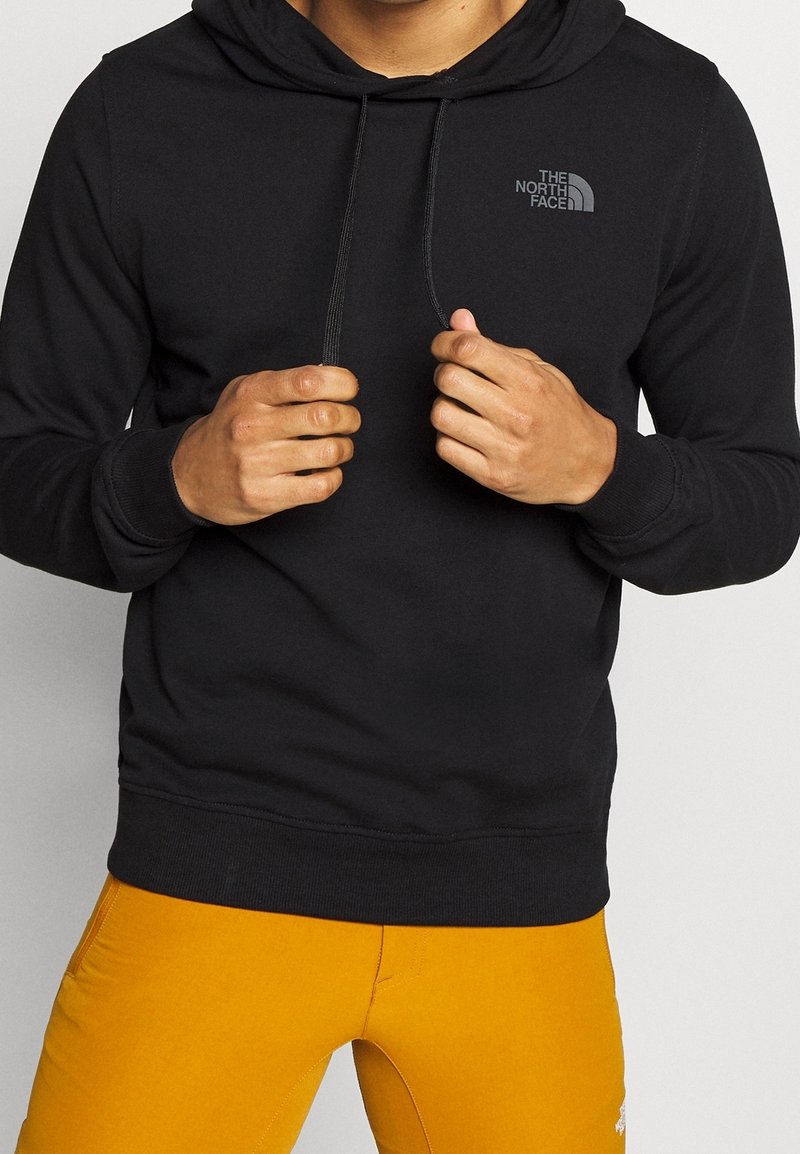 Hoodie noir avec cordons de serrage, arborant un petit logo gris sur la poitrine gauche. Tissu doux, poignets et taille côtelés.