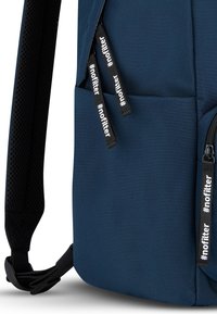 Navy backpack with textured fabric, zippered front pocket, mesh strap, and decorative black pull tabs with white text.