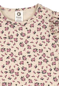 Light beige t-shirt made of soft cotton with small pink and navy floral print. Features a round neckline and frilly sleeves.