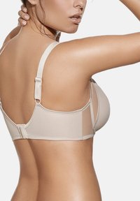 Sujetador de encuadernación en color beige con una tela suave, tirantes ajustables y cierre de gancho y ojos. Presenta paneles laterales transparentes para agregar textura.