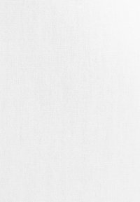 Tissu blanc texturé avec un motif de tissage serré, montrant de petites boucles régulièrement espacées et une surface lisse.