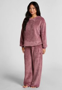 Fleece loungewear-set in gedempte paarstinten, met een losvallende trui met ronde hals en bijpassende broek met wijde pijpen. Overal een zachte textuur.