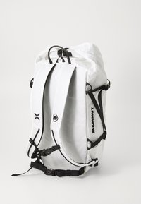 Rucsac alb fabricat dintr-un material texturat, cu bretele și catarame negre, un mânere de sus și logo-ul "MAMMUT" pe latură.