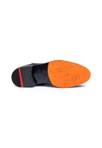 Suola nera della scarpa con una suola esterna in gomma arancione caratterizzata da un motivo di forme geometriche e una striscia rossa in evidenza. Gomma testurizzata per una migliore aderenza.