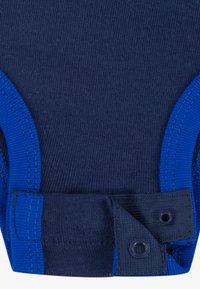 Temno modra bodysuits z rebrasto tkanino, kontrastnim modrim obrobom in gumbom na dnu za enostavno oblačenje.