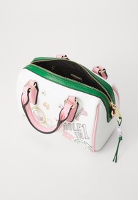 Borsa sintetica bianca con manici rosa, cerniera verde e hardware dorato. Presenta stampe colorate a tema golf e un rivestimento interno nero.