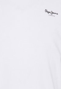 T-shirt bianco in cotone con un piccolo logo nero "Pepe Jeans London" sul lato sinistro in alto. Tessuto liscio, design a girocollo.