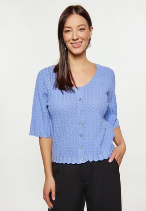 Lichtblauwe gebreide cardigan met een V-hals, golvende zoom, halve mouwen en knoopsluiting aan de voorkant. Heeft een textuurpatroon en doorzichtige knopen.