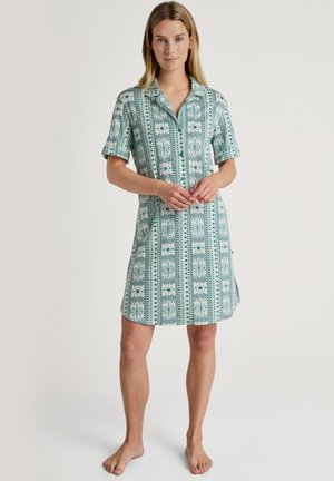 Abito camicia a maniche corte in teal e crema con un motivo geometrico, colletto e spacco laterale per facilitare i movimenti.