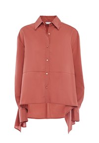 Camicia a maniche lunghe di colore corallo realizzata in tessuto morbido. Presenta una chiusura con bottoni, colletto a punta e un orlo posteriore più lungo con lati spaccati.