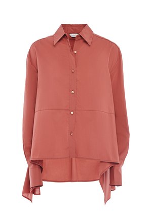 Chemise à manches longues de couleur corail en tissu lisse. Elle présente un devant boutonné, un col pointu et un ourlet arrière plus long avec des côtés fendus.