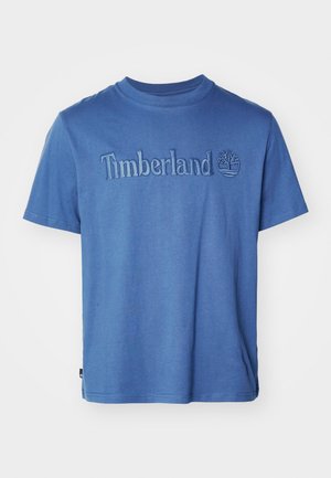 T-shirt en coton bleu avec col rond, manches courtes et logo "Timberland" brodé avec un design d'arbre en dessous. Texture lisse, coupe décontractée.