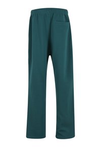 Sirelrohelised sirge säärega püksid elastse vöökohaga ja ühe tagataskuga, nähtud tagantvalgel taustal.