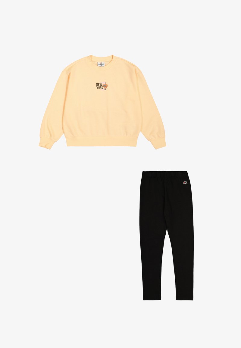 Sudadera ligera amarilla con gráfica de "NEW YORK"; joggers negros ajustados con cintura elástica y logo. Tejido de mezcla de algodón, diseño casual.