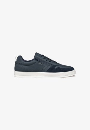 Baskets basses noires pour homme avec semelle blanche, fermeture à lacets à l'avant, fermeture éclair latérale et détail de marque sur panneaux lisses et en daim.