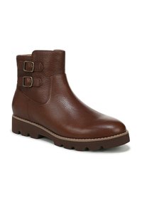 Brown leather ankle boot with two decorative buckles, rounded toe, textured finish, and rugged sole for traction.