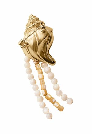 Broche en forma de concha con tono dorado y tres hilos colgantes de cuentas redondas y cuadradas de color crema.