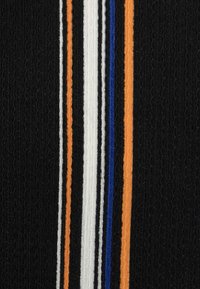 Tela negra con rayas verticales en naranja, blanco, azul y negro, con una superficie texturizada y un patrón acanalado.