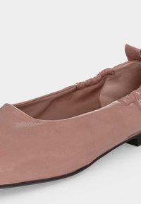 Μαλακό ροζ δερμάτινο παπούτσι μπαλαρίνα με ελαστική πλεκτή πλάτη και χαμηλό μαύρο τακούνι, εμπρός γωνιακό για πλαϊνή όψη.